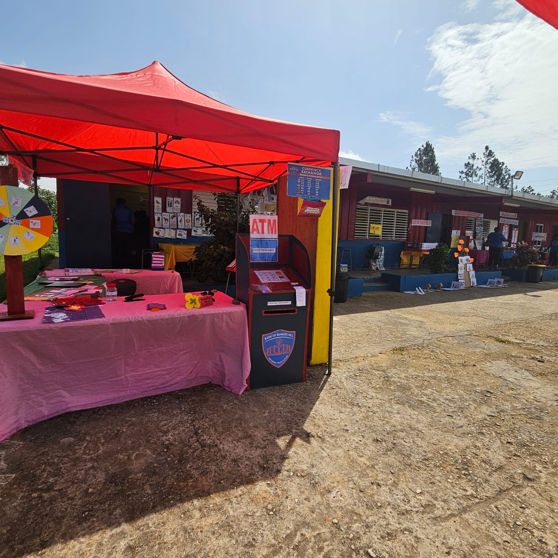 Outdoor learning displays beneath a red canopy in the school courtyard