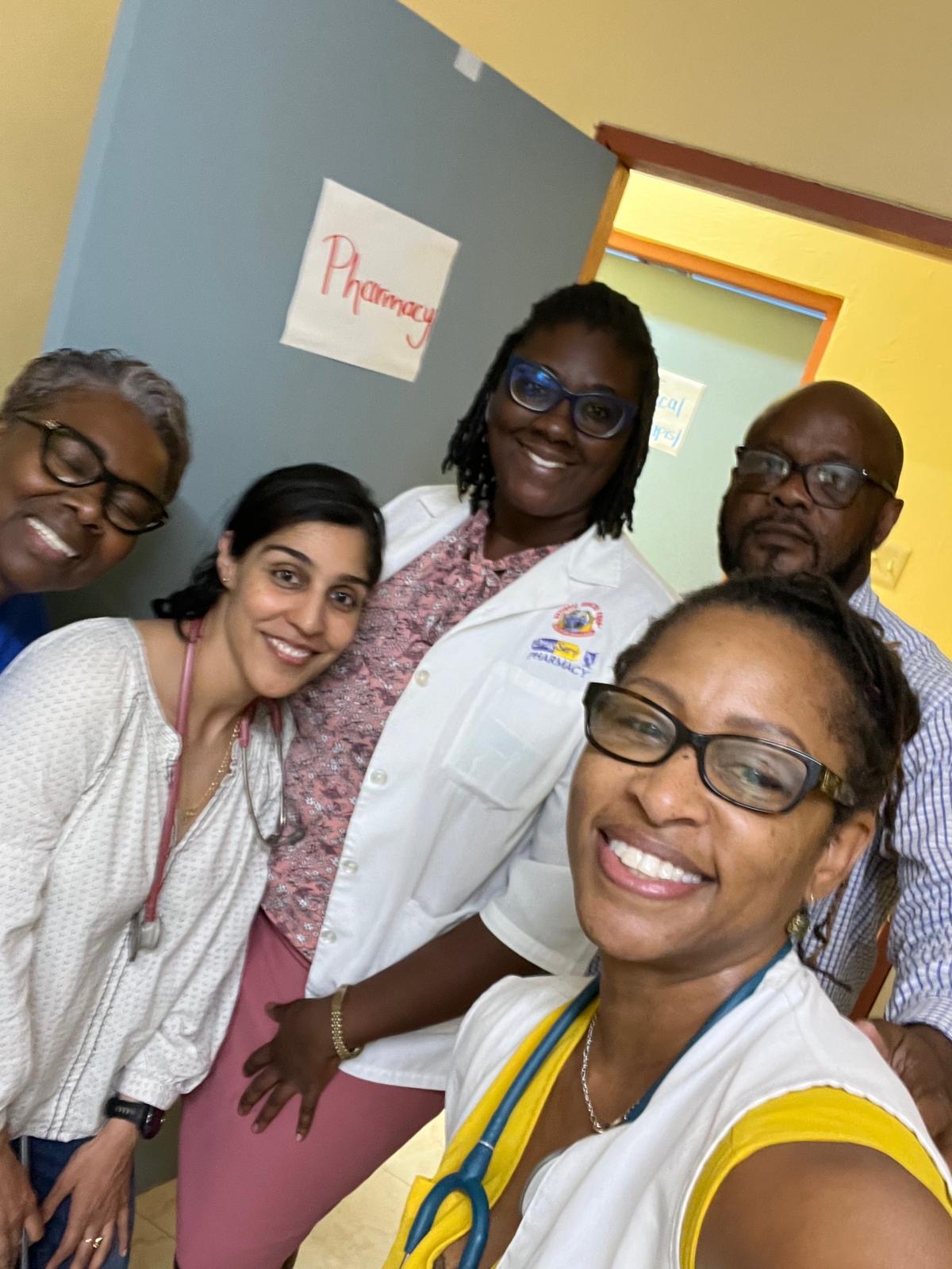 Five smiling healthcare volunteers together in a clinic during the 2026 mission in Jamaica