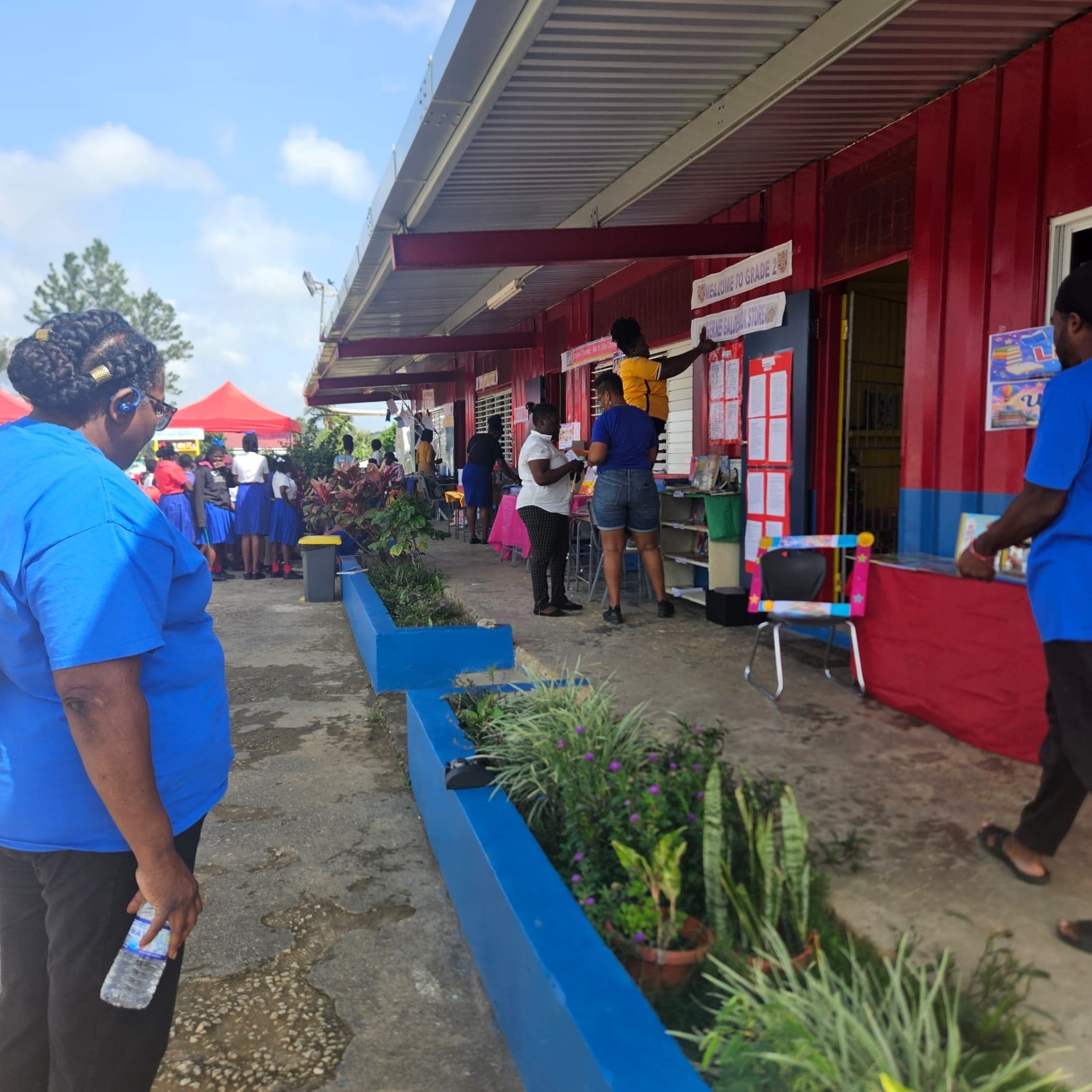 Adults and pupils exploring displays along the school’s red and blue exterior